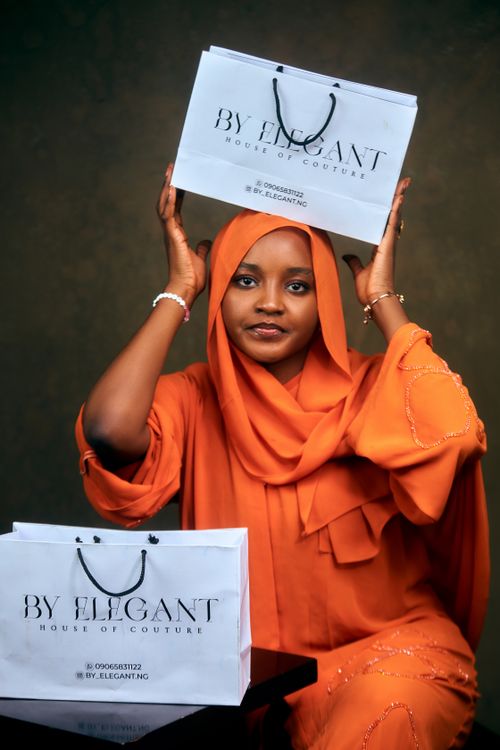Free Woman in orange hijab holding shopping bags from By Elegant. Stylish fashion shot. Stock Photo
