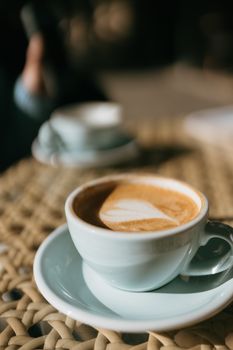 Warm latte with heart-shaped art in a white cup, perfect for coffee lovers.