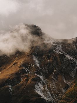 A rugged mountain peak enveloped by mist, showcasing nature's dramatic beauty.