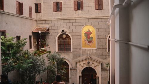 Free View of a serene church courtyard in Istanbul featuring religious artwork and lush greenery. Stock Photo
