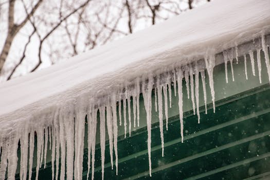 Winter scene of icicles hanging from a rooftop after heavy snowfall.