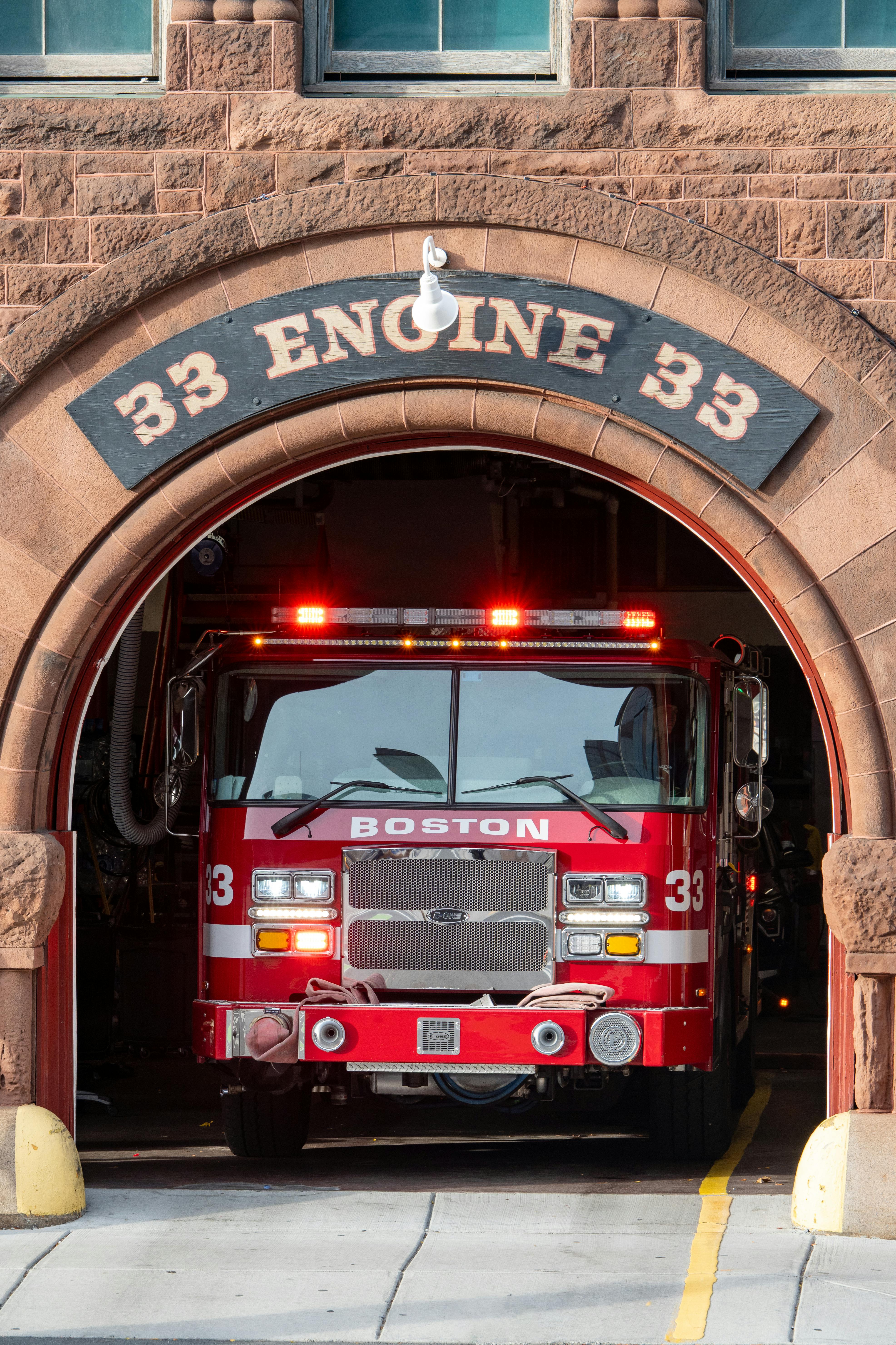 Free Red fire truck at Boston's Engine 33 station, ready for emergency response. Stock Photo