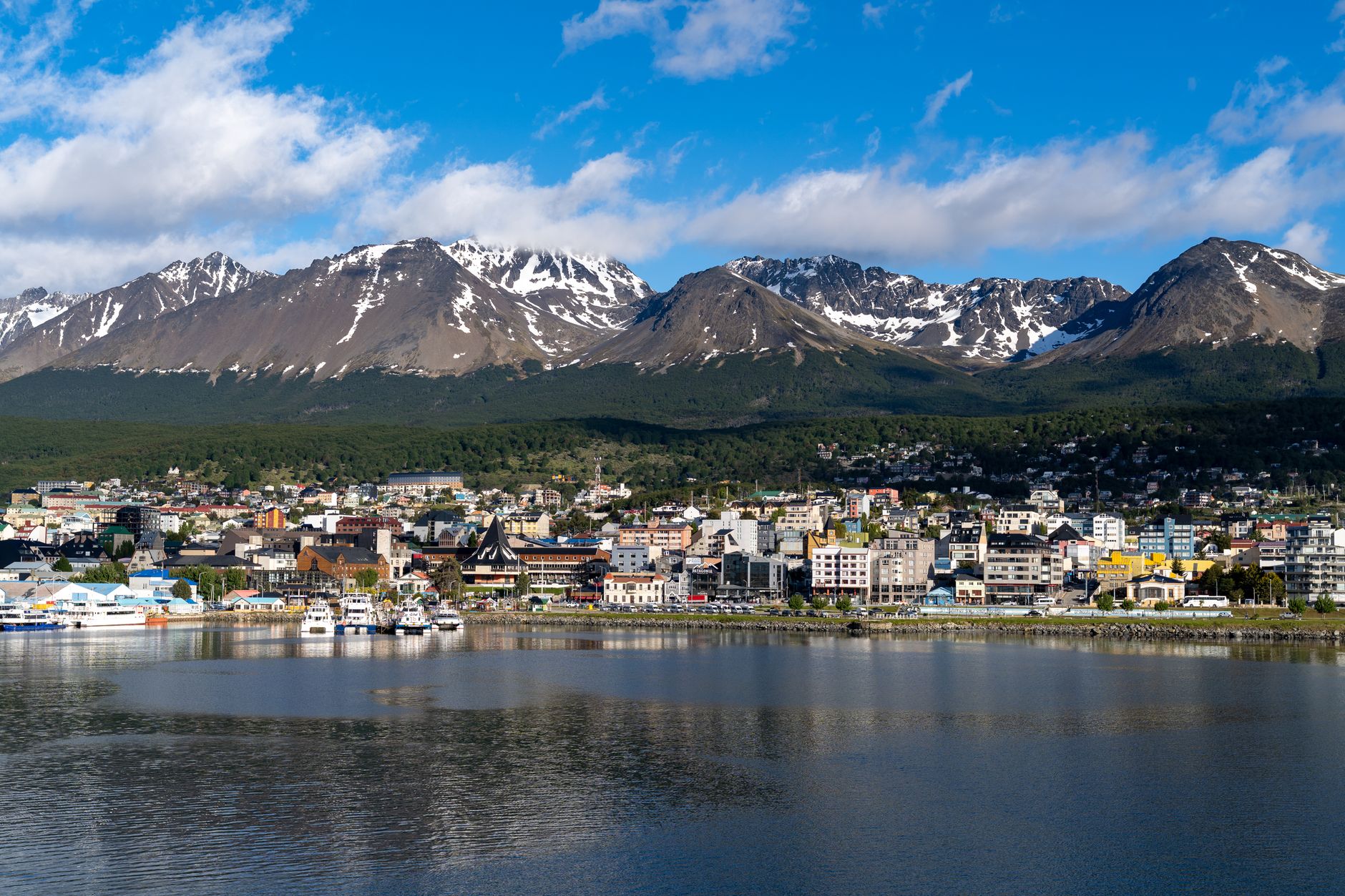 Discover the stunning cityscape of Ushuaia, Argentina with snow-capped mountains as a backdrop.