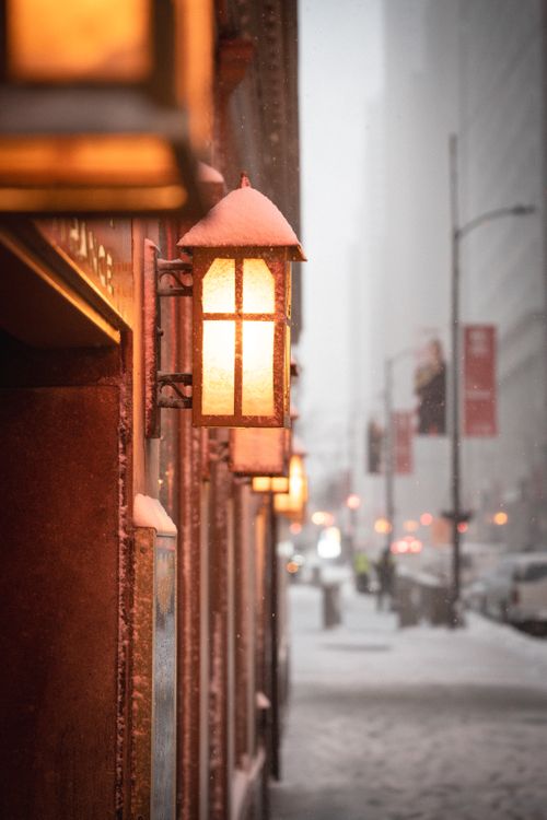 Free Cinematic view of an antique lamp on a snowy Chicago street during a winter storm. Stock Photo