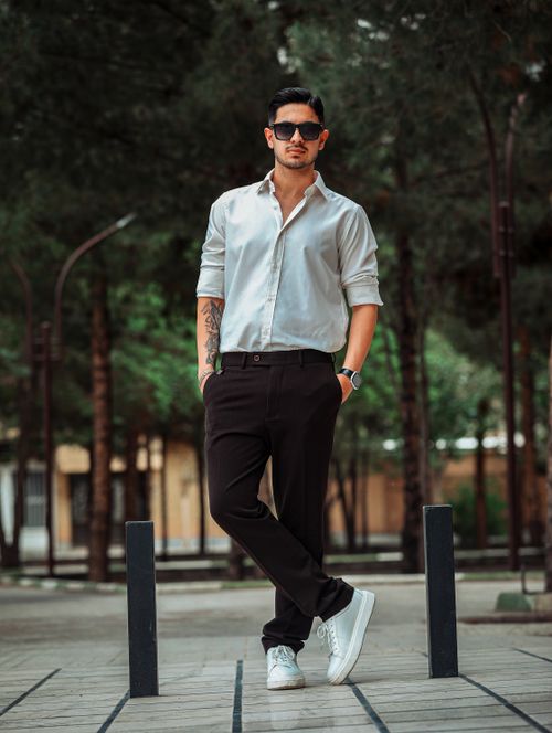 Free Fashionable male in sunglasses and smart casual attire posing outdoors, exuding confidence. Stock Photo