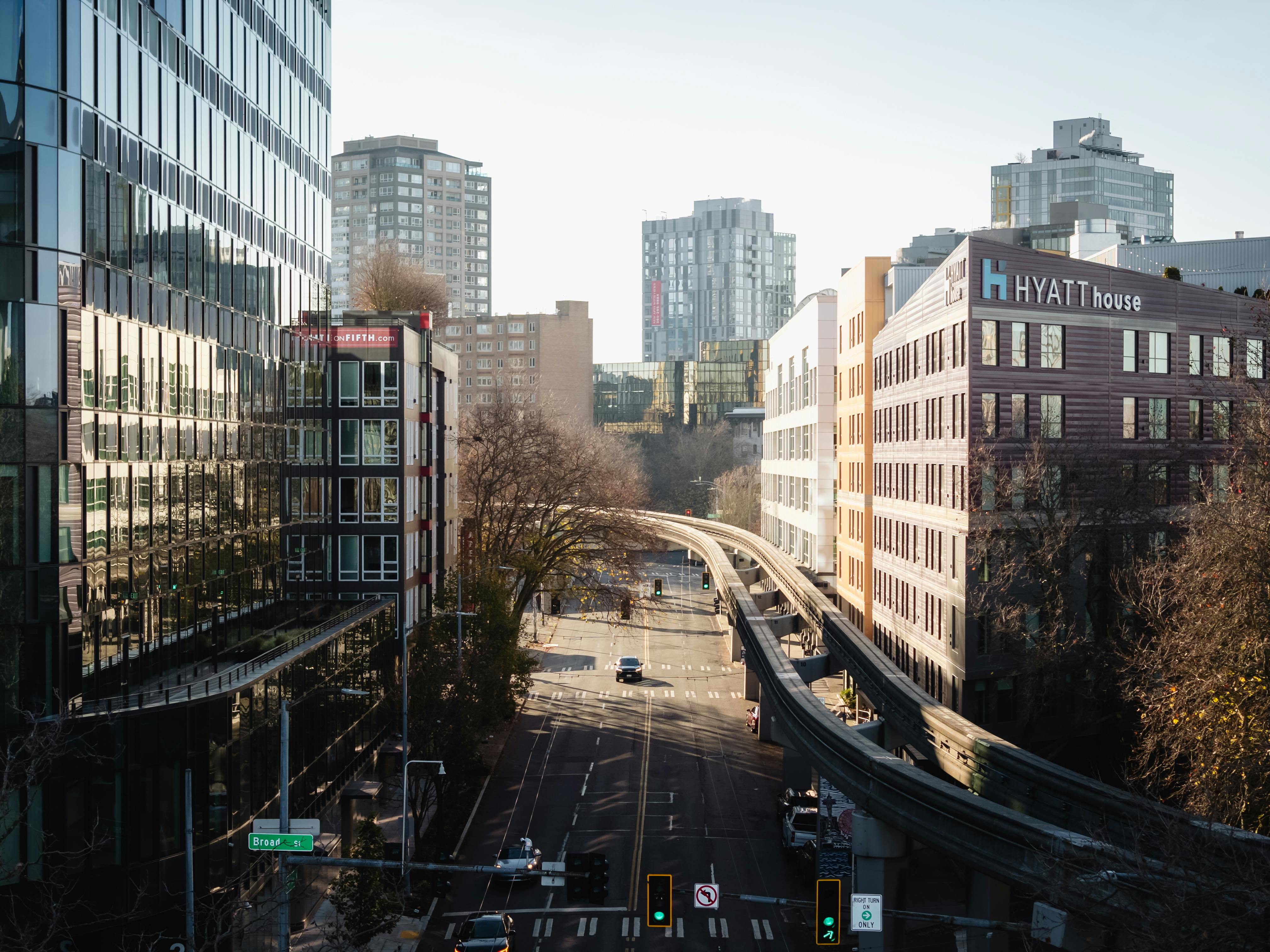 Aerial view of a Seattle city street with modern architecture and monorail tracks.