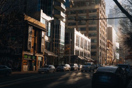 Free Urban street scene in Seattle, Washington, capturing early morning hustle and bustle with sunlight illuminating city buildings. Stock Photo