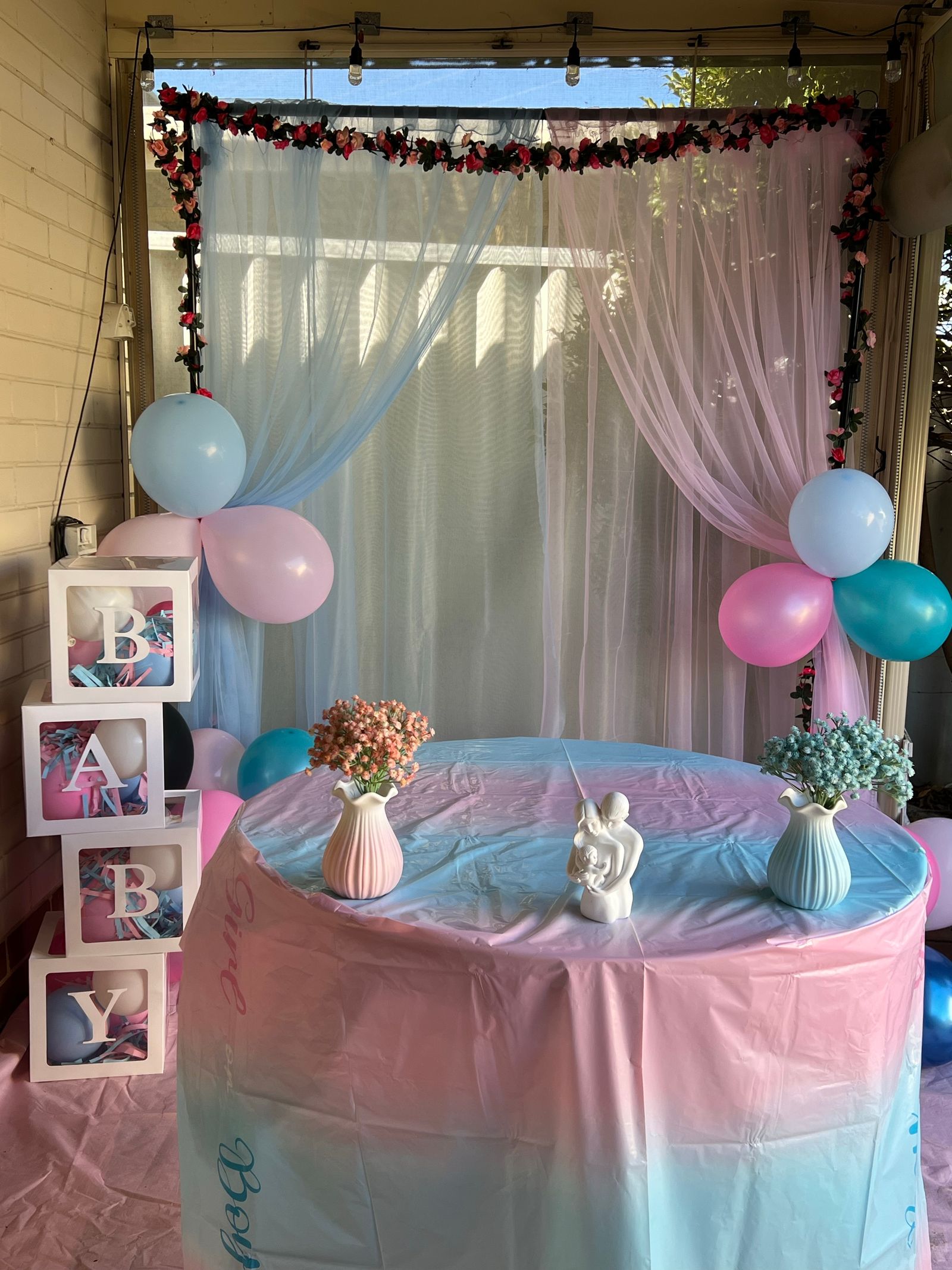 Pastel baby shower table styling with balloons and floral details