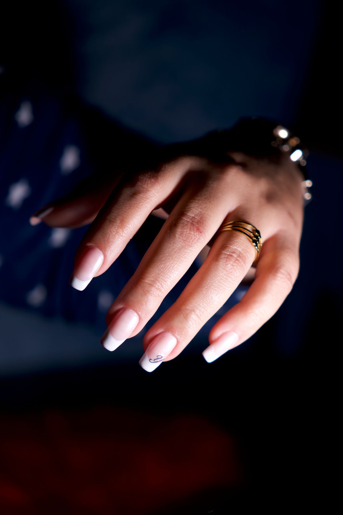 French manicure with gold jewelry