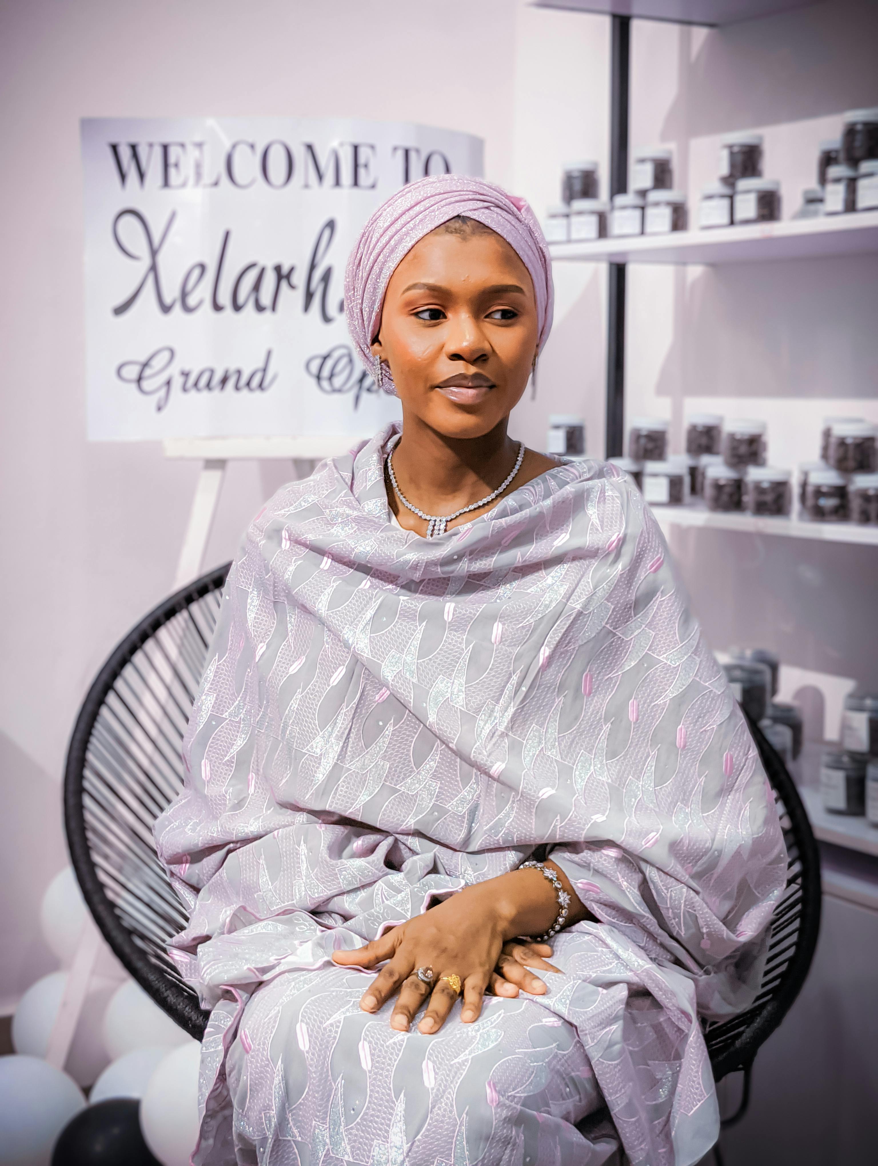 Elegant woman in traditional attire at Xelarha store opening event. Modern and stylish setting indoors.