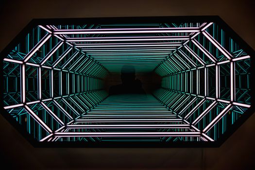 An abstract view inside a neon-lit tunnel creating a futuristic effect with vibrant colors.