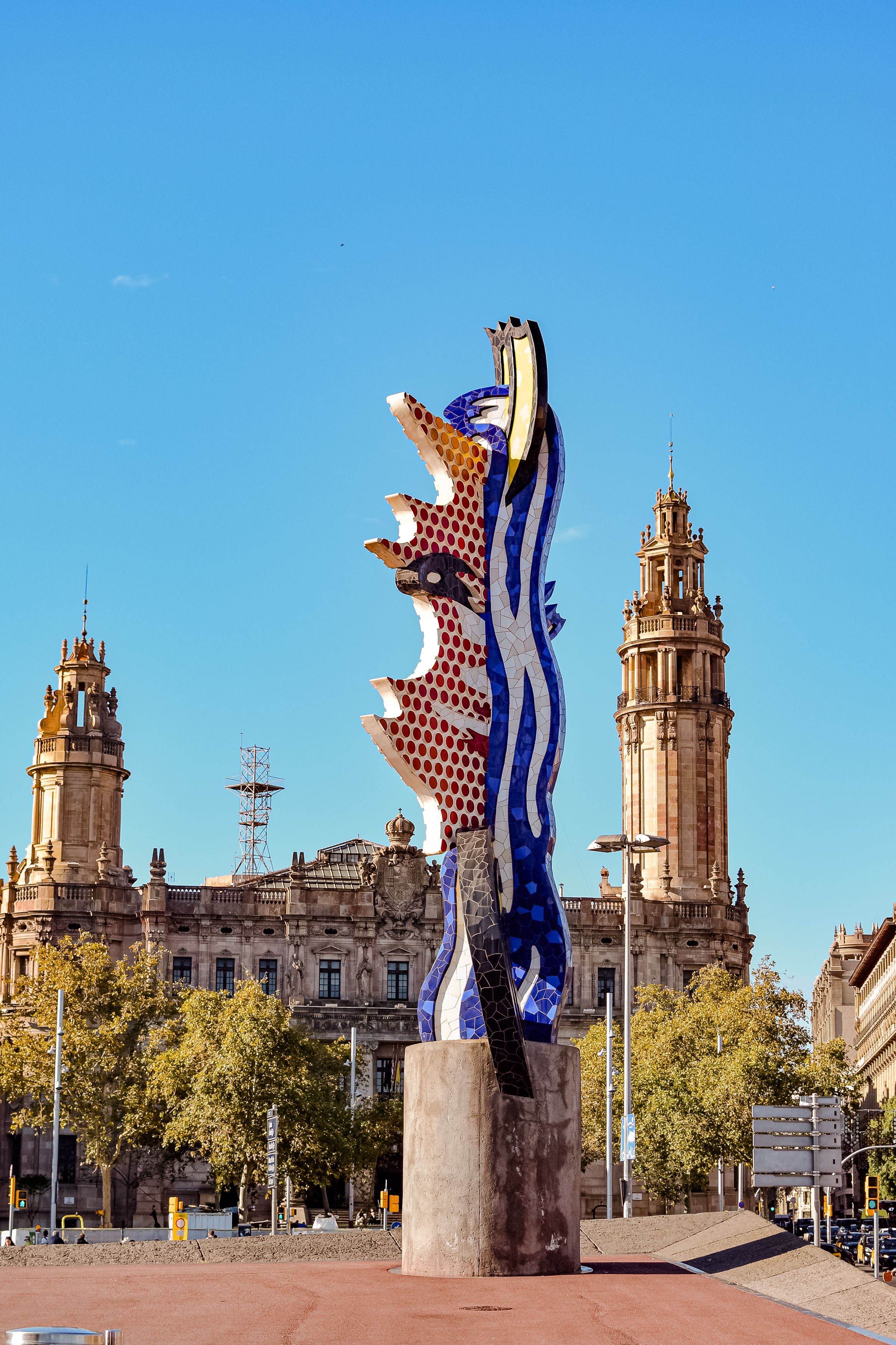 Vibrant sculpture set against historical architecture in Barcelona, showcasing art and city life.