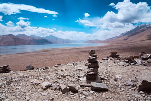 Free A stunning view of Pangong Tso Lake in Ladakh with rocky cairns in the foreground. Stock Photo