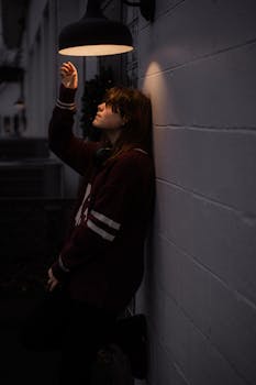 A moody scene of a woman under a streetlight, creating a dramatic and artistic atmosphere.