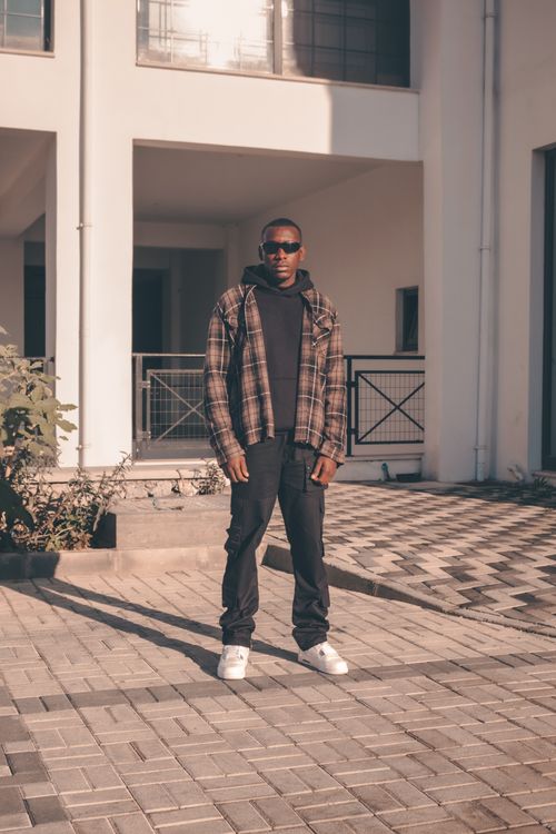 Free Stylish man wearing sunglasses standing in paved outdoor area during daytime. Stock Photo