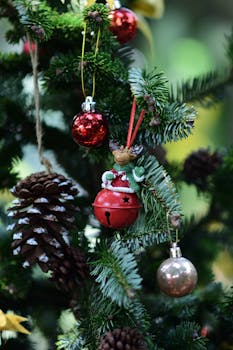 Close-up of Christmas tree with festive ornaments and pine cone.