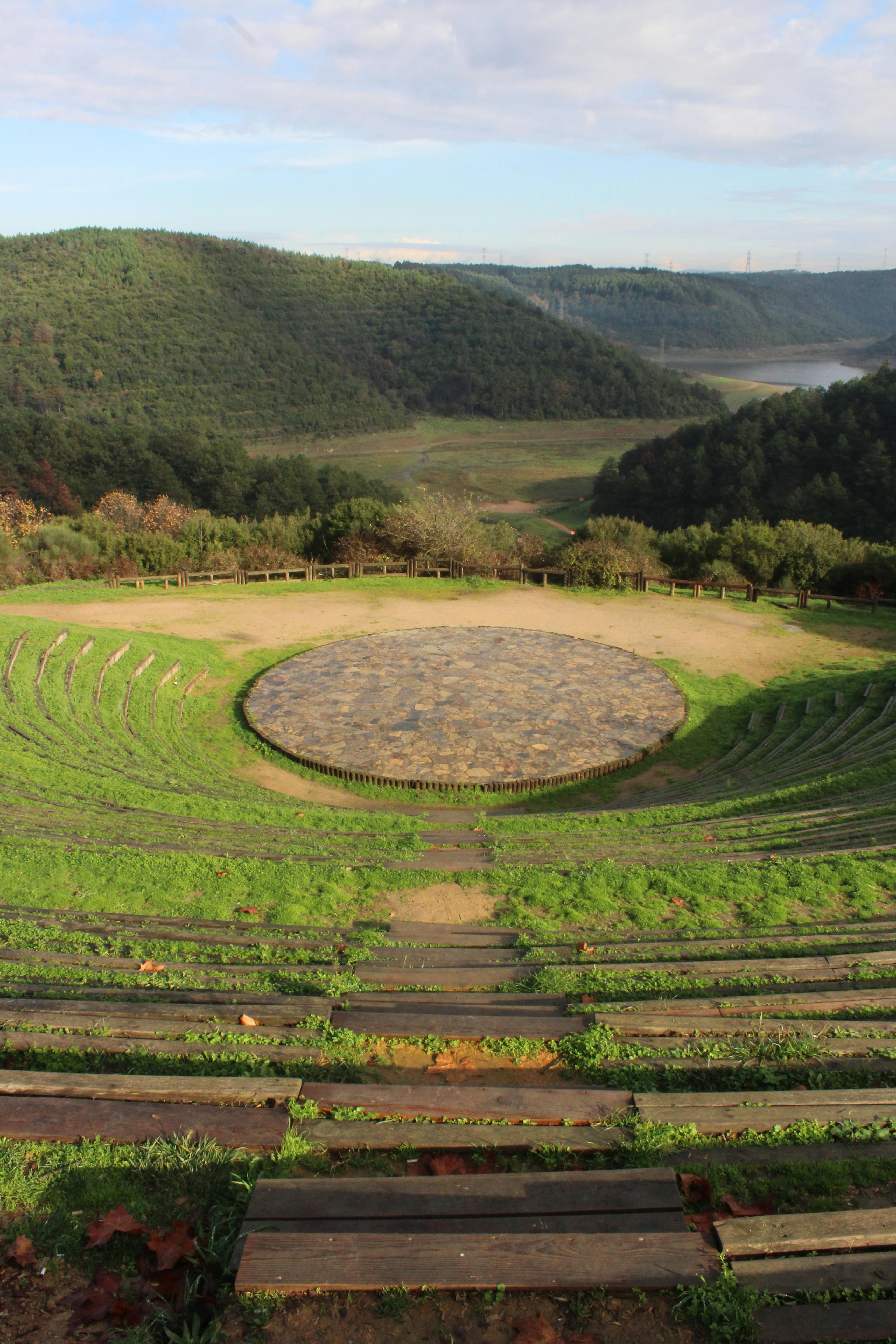 Gratuit Un amfiteatru pitoresc cuibărit într-o vale verde înconjurată de dealuri împădurite. Fotografie de stoc