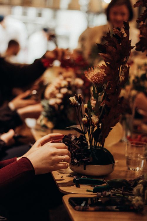 Free Adults arranging flowers in a warm, inviting indoor setting. Perfect for lifestyle themes. Stock Photo