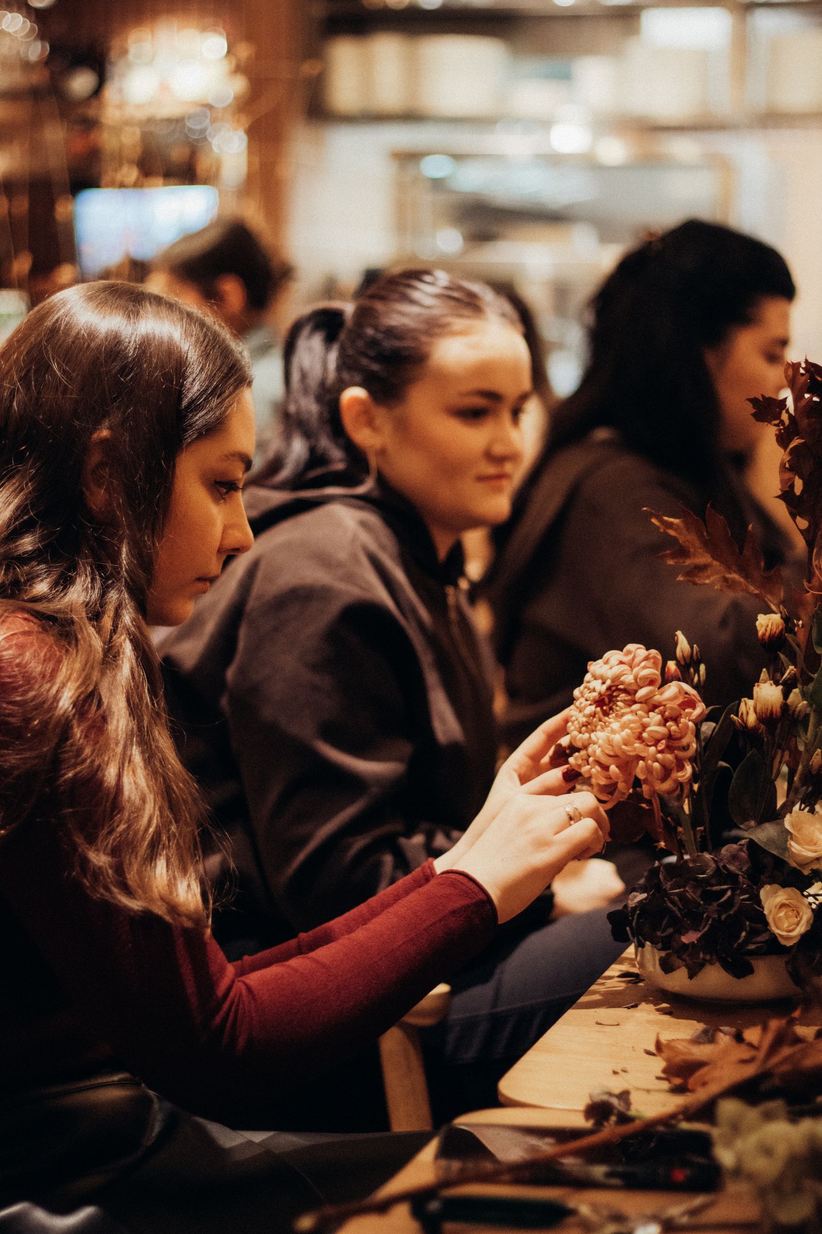 A small group working together on flower arrangements at a table.