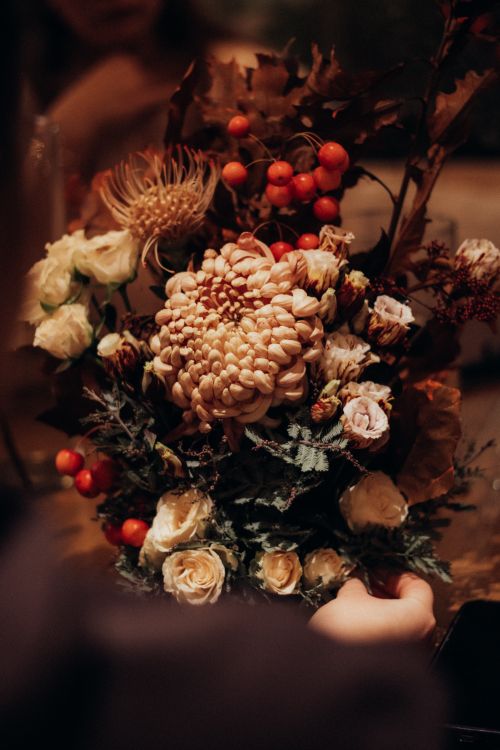 Free Warm-toned floral arrangement featuring autumnal flowers and berries. Stock Photo