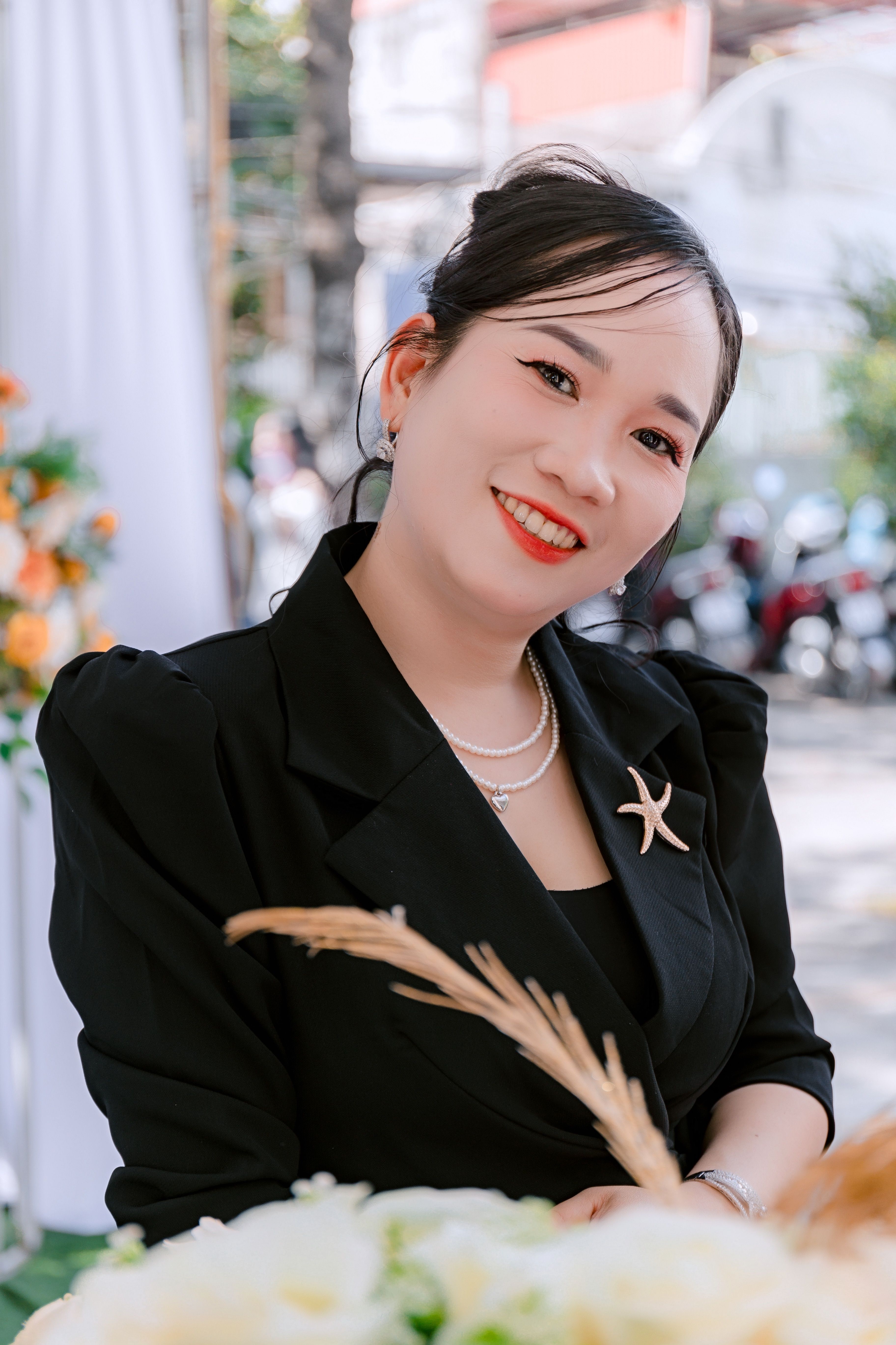 Charming woman outdoors in a black outfit, exuding elegance and confidence.