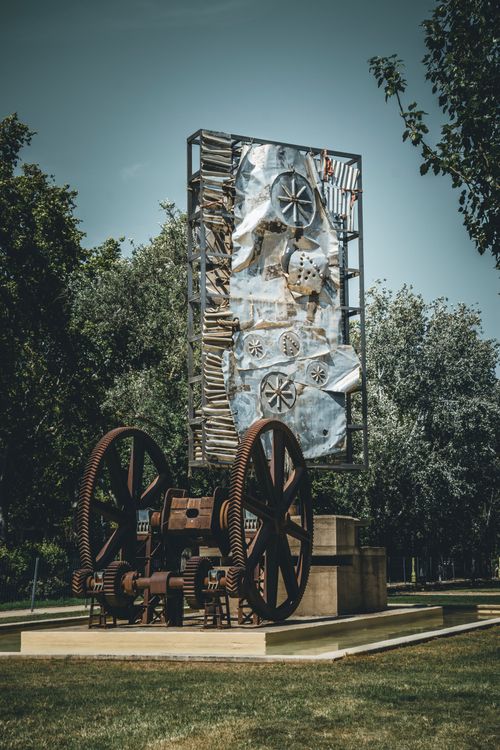 Free A striking industrial-style sculpture with gears in a Barcelona park, showcasing modern art. Stock Photo