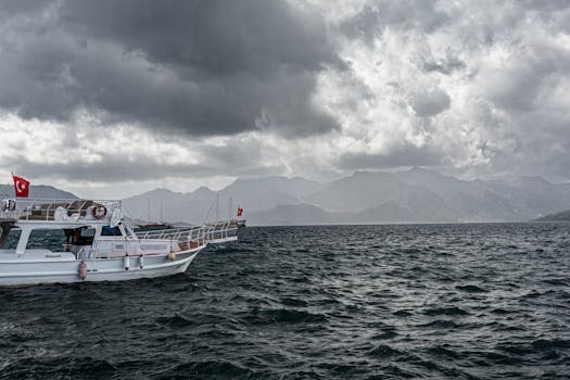 A dramatic seascape with boats under storm clouds, featuring the Turkish flag.