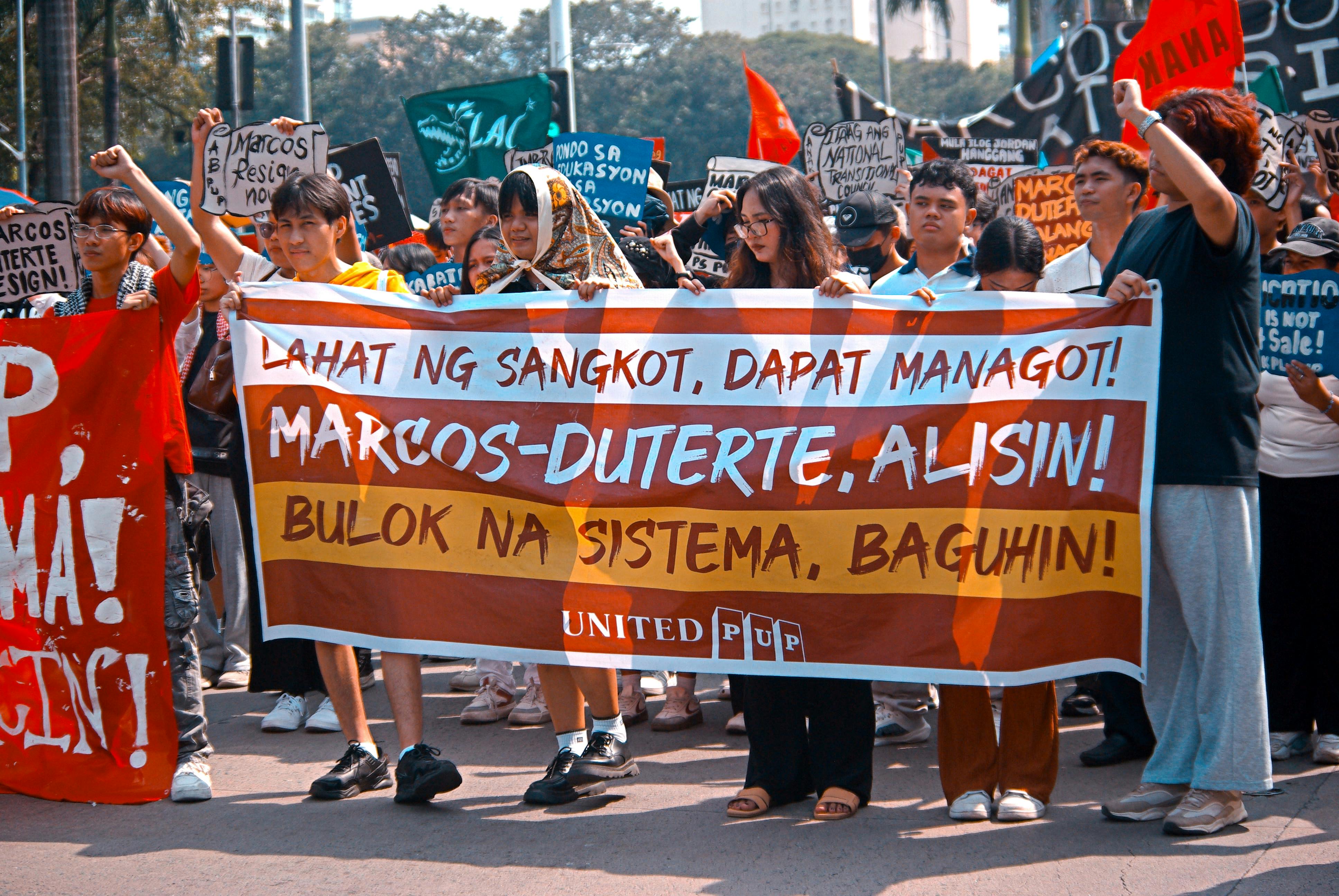 A public protest with people holding banners calling for political change.