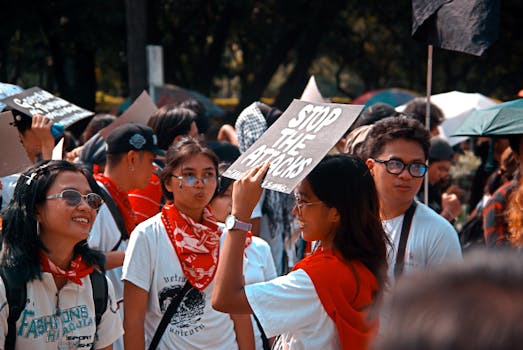 A dynamic protest scene featuring a crowd with a prominently displayed 'Stop the Attacks' sign.