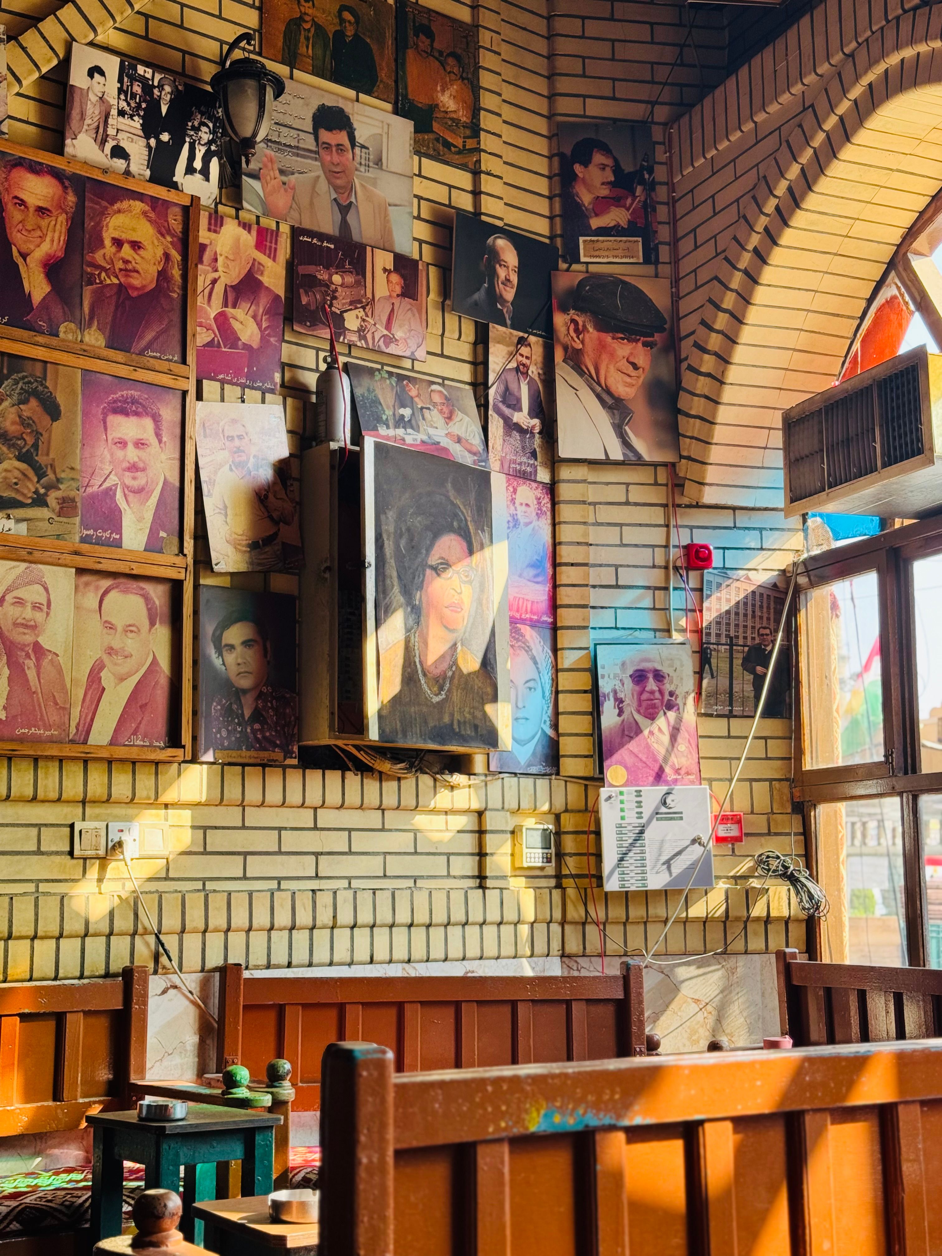 A wall in an Erbil café adorned with photos of famous personalities.