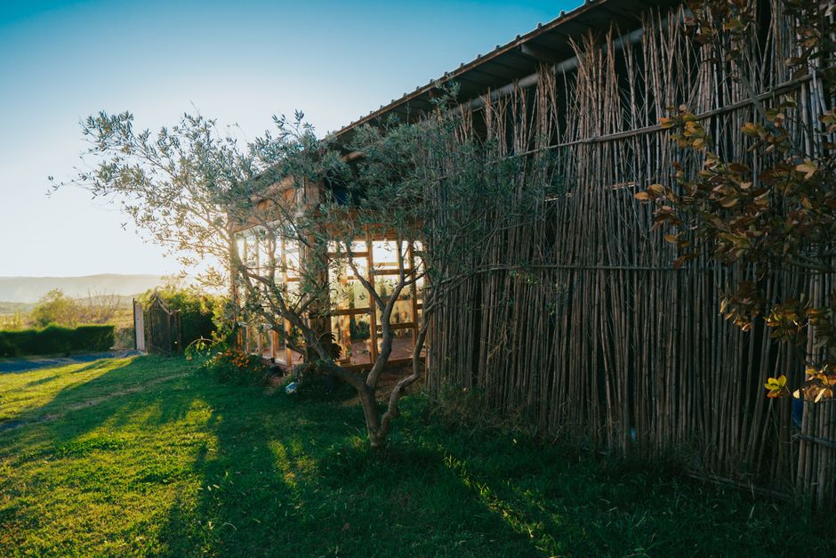 A serene rural scene in Fishtë, Albania, capturing a bamboo house during golden hour.