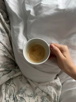 A cozy morning scene with espresso in bed, epitomizing relaxation.