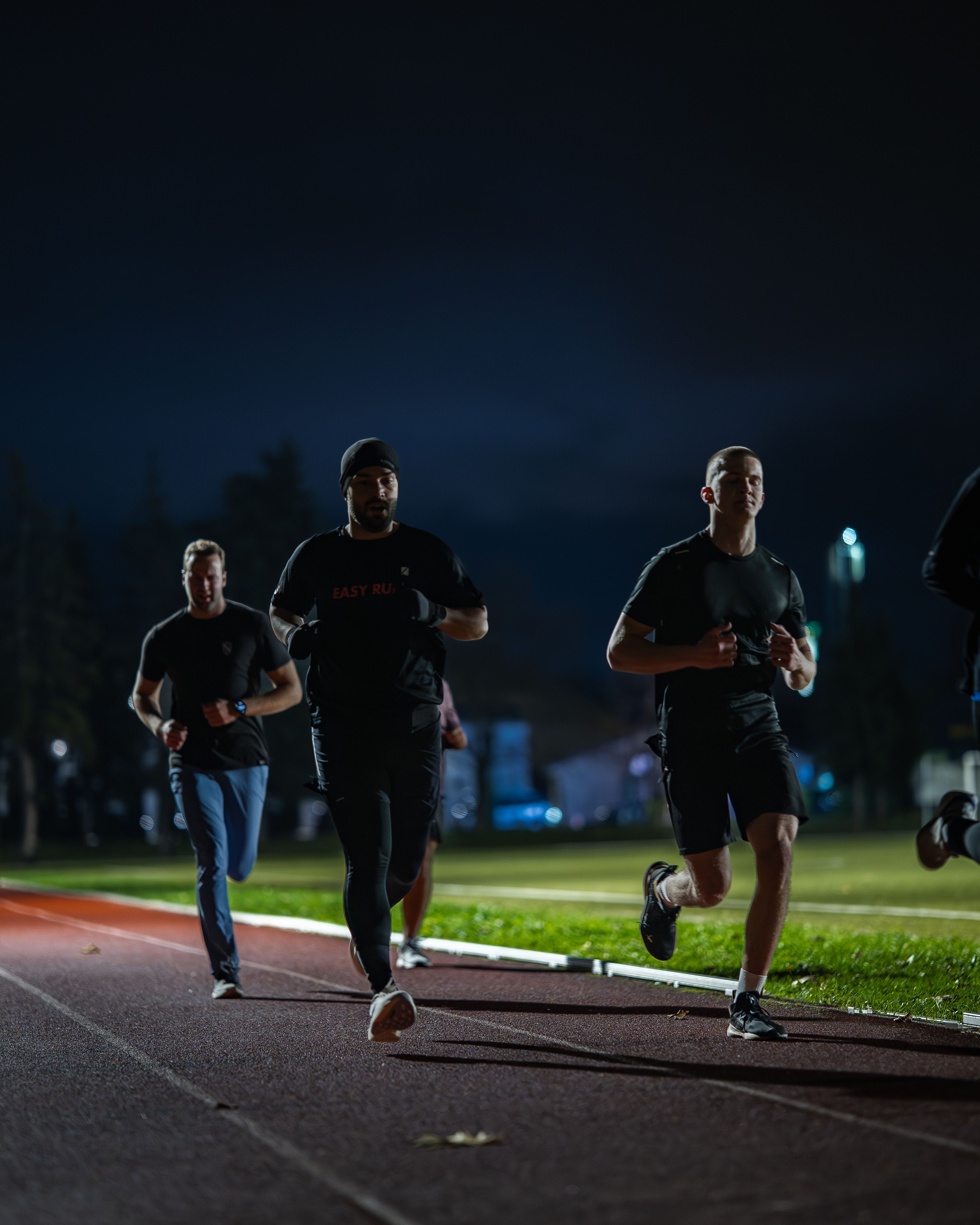 Corredores participando en una carrera nocturna con iluminación urbana