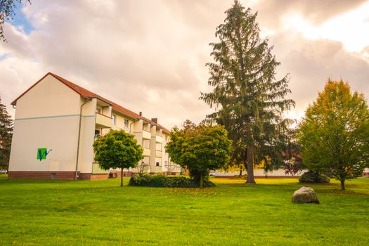 Scenic autumn setting in a peaceful Lower Saxony neighborhood with lush trees and residential architecture.