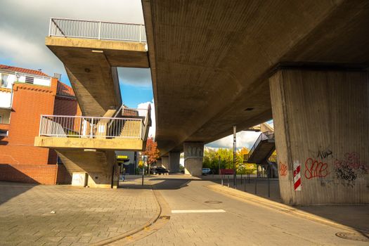 Concrete urban design beneath blue skies highlighting autumn colors in Lower Saxony, Germany.