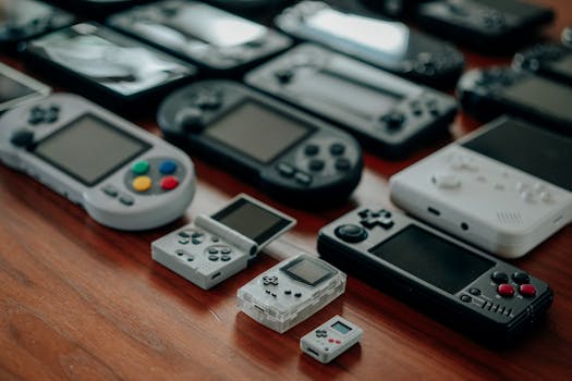 Collection of diverse retro handheld gaming consoles on a wooden surface, showcasing classic designs and nostalgia.