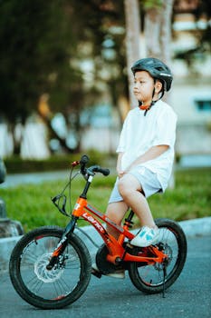 Young boy enjoying a bicycle ride outdoors in Kon Tum, Vietnam.