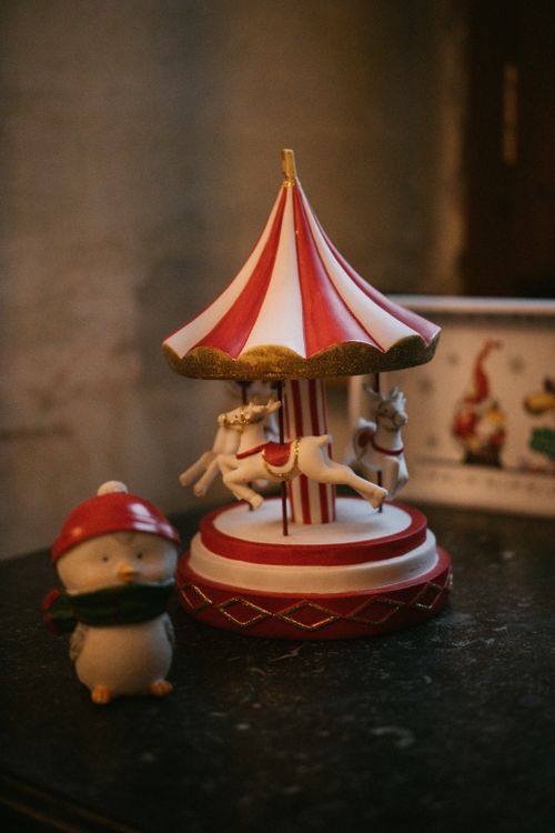 Free Charming vintage carousel and winter figurine capturing festive holiday spirit indoors. Stock Photo