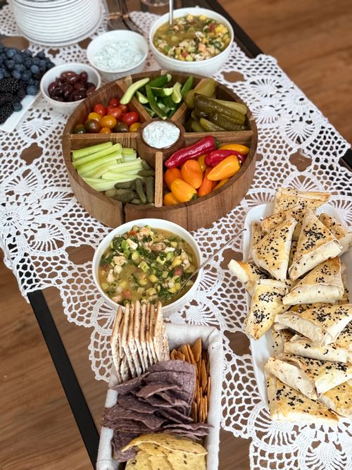 Free A beautifully arranged table with a variety of appetizers, dips, and crackers on a lace tablecloth. Stock Photo