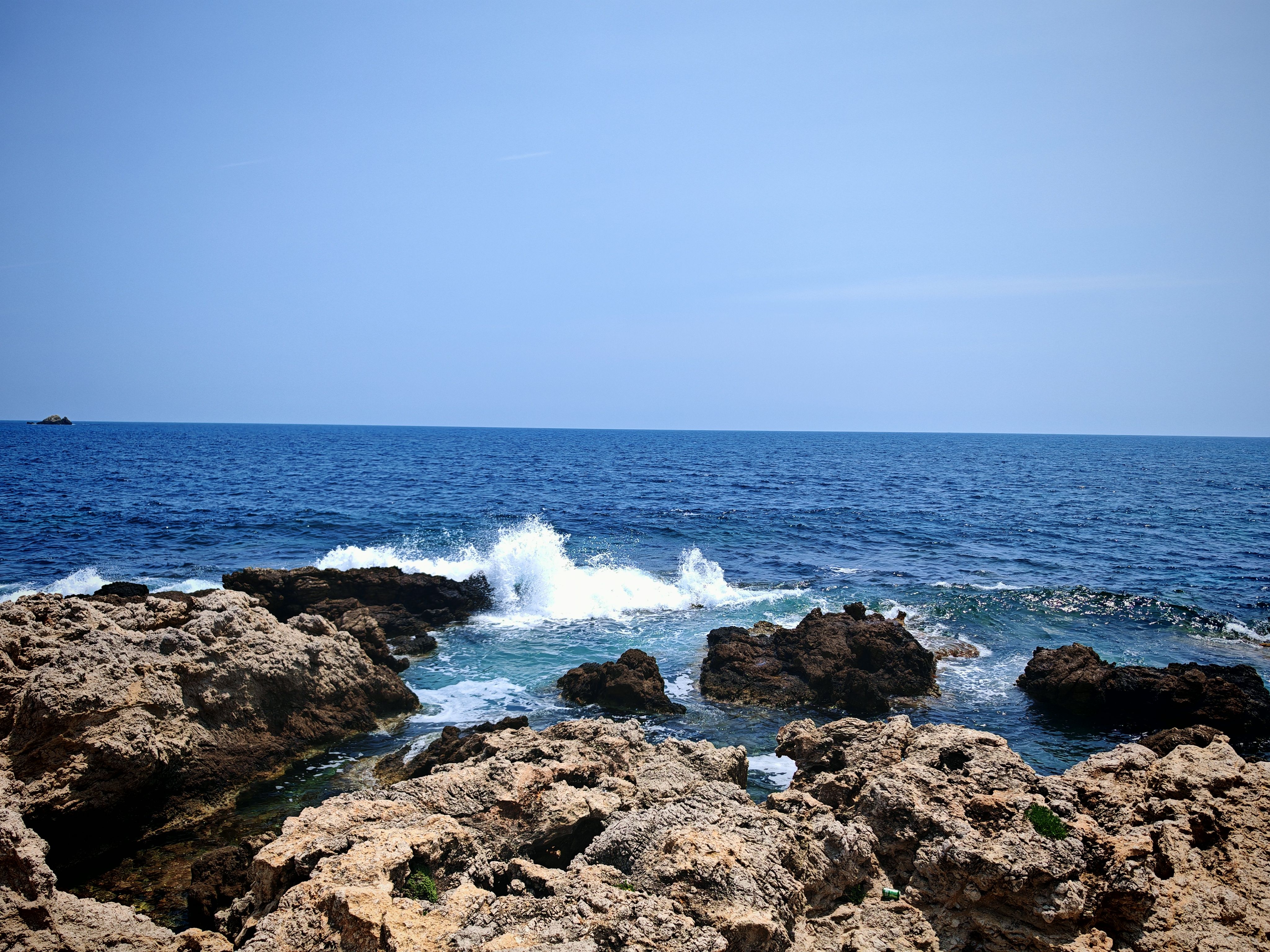 Waves Crashing on Rocky Shoreline in Summer · Free Stock Photo