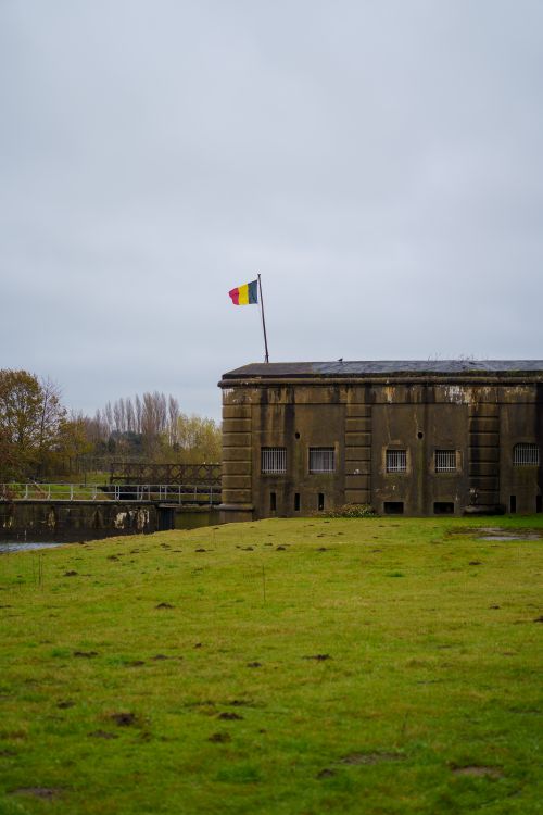 Free Photograph of a historic fort with the Belgian flag in Willebroek, Belgium. Stock Photo