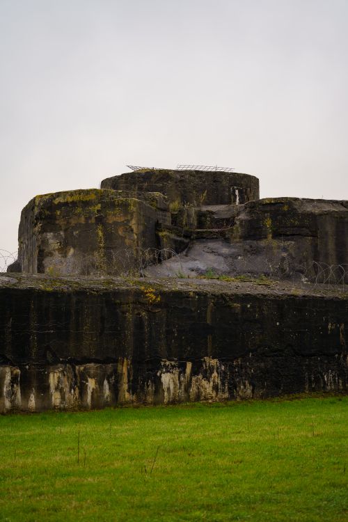 Free Old concrete bunker surrounded by barbed wire in Willebroek, Belgium. Dramatic and historic atmosphere. Stock Photo
