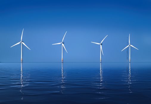 Serene landscape of offshore wind turbines reflecting on calm ocean water.