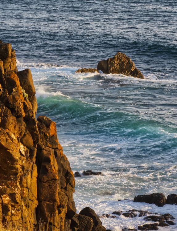 Golden Hour Ocean Waves against Rocky Shore · Free Stock Photo