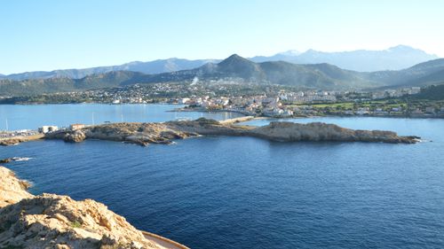 Free A stunning view of L'Île-Rousse in Corsica, featuring clear blue waters and surrounding mountains. Stock Photo