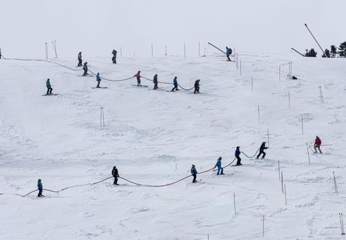 Group of skiers ascending snowy slopes in Andorra during winter training session.
