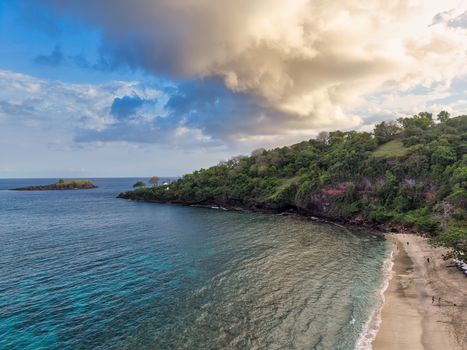 Breathtaking aerial shot of a tranquil beach and lush greenery in Bali, Indonesia.