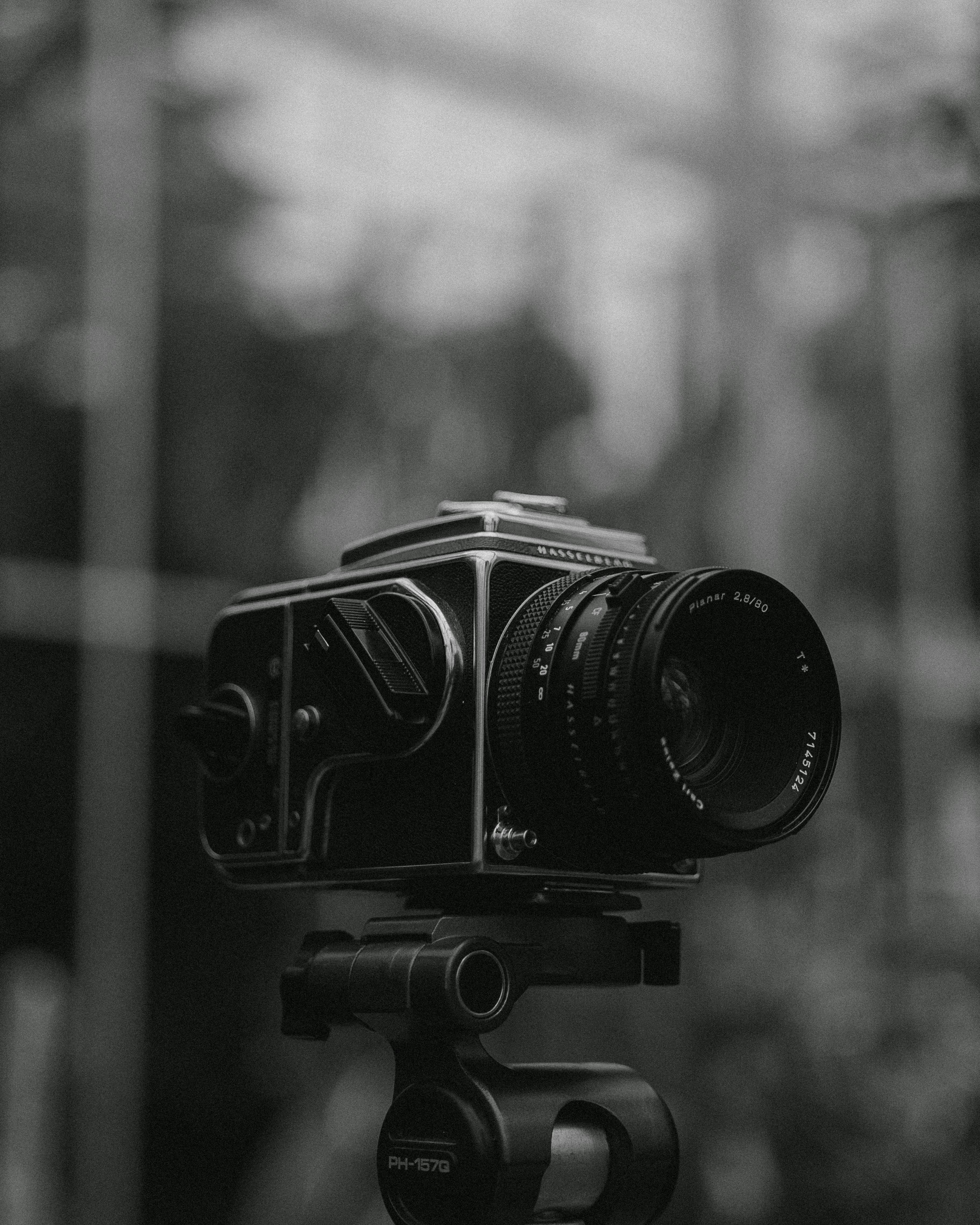 A classic vintage camera mounted on a tripod, photographed in black and white for a timeless look.