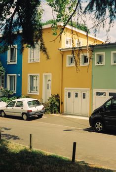 Vibrant row houses in Rennes, France, showcasing colorful architecture under clear skies.