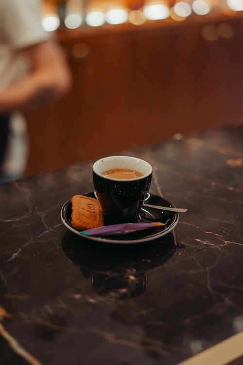 Free A stylish shot of espresso with snacks on a marble counter in Rennes, France. Stock Photo